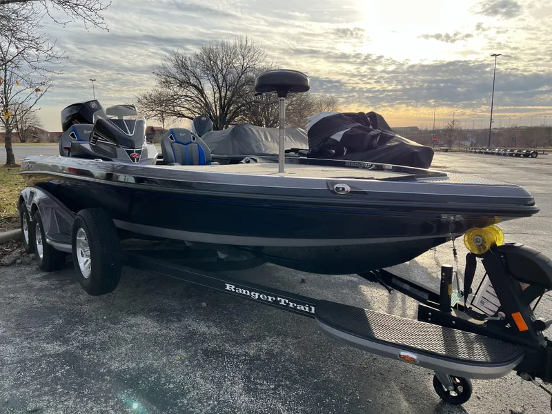Slide: The Image of 2023 Ranger Z520R boat on a Ranger Trail trailer in a parking lot. - 2
