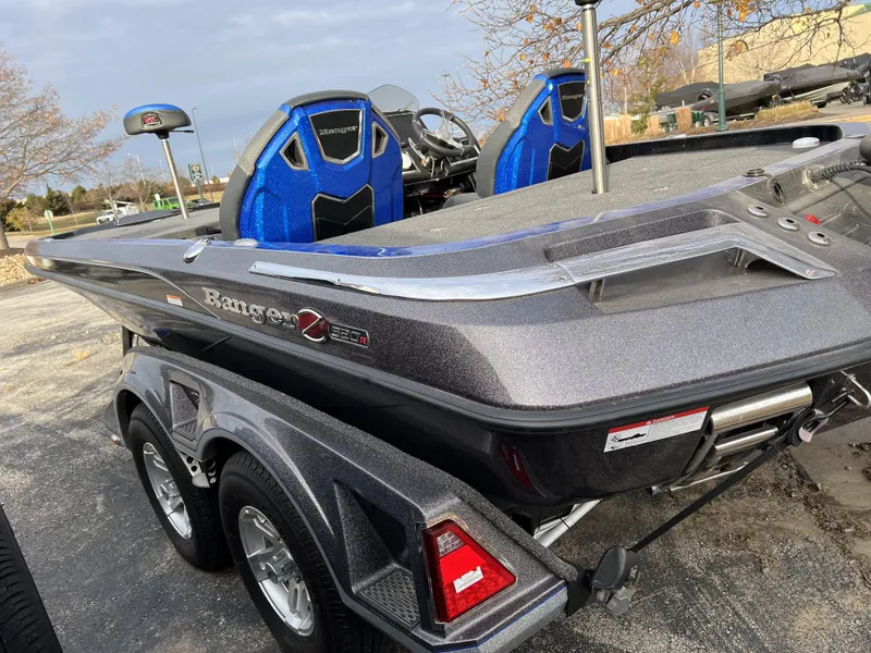 Slide: The Image of 2023 Ranger Z520R bass boat with dual axle trailer, blue seats, and sleek design. - 5