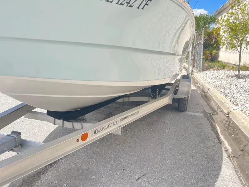 Slide: The Image of Clearwater 2000 boat on a trailer, model year 2022, parked on a sunny street. - 7