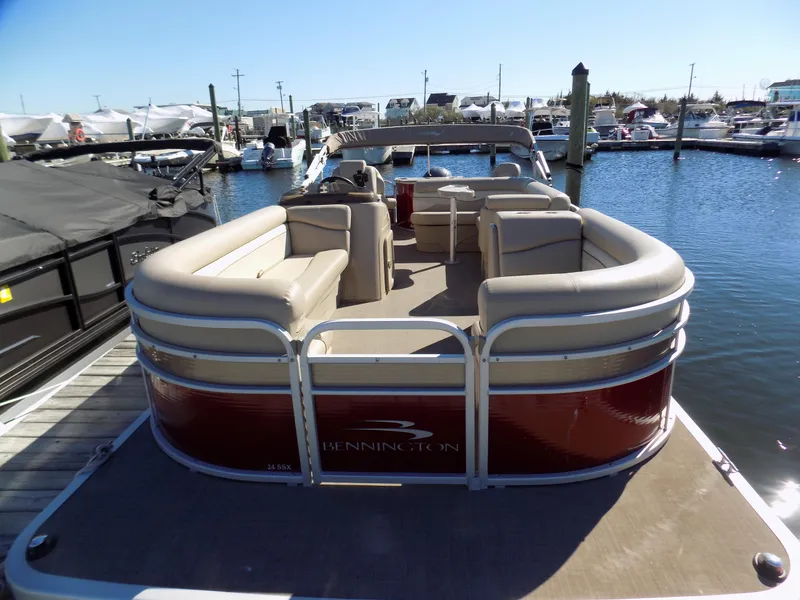 Slide: The Image of 2015 Bennington 24 SSX pontoon boat docked at marina, featuring spacious seating. - 1