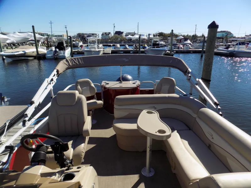 Slide: The Image of 2015 Bennington 24 SSX pontoon boat with beige seating, docked in a marina. - 3