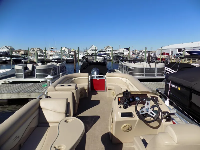 Slide: The Image of 2015 Bennington 24 SSX pontoon boat docked at a marina under clear blue skies. - 4