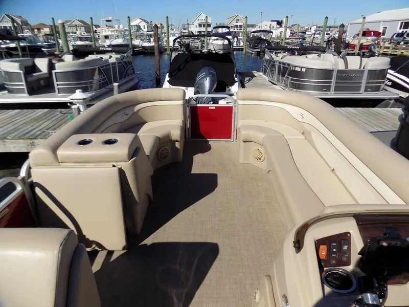Slide: The Image of 2015 Bennington 24 SSX pontoon boat with spacious seating, docked at a marina. - 5