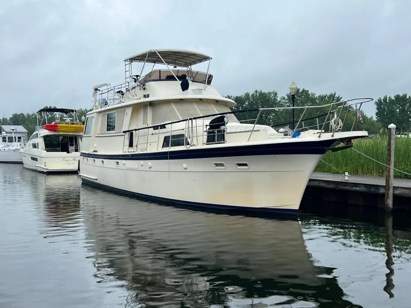 The Image of 1978 Hatteras 58 MY yacht docked in a serene marina setting. - 0