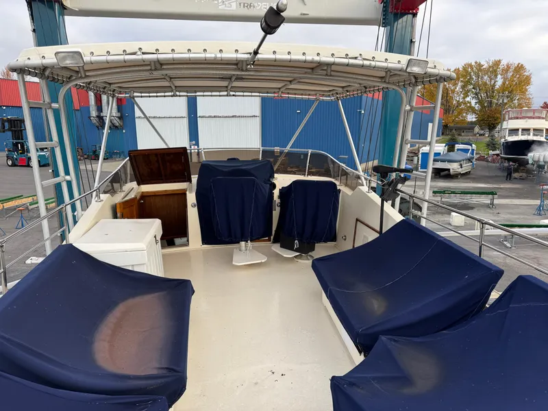 Slide: The Image of 1978 Hatteras 58 MY yacht deck with blue-covered seating and canopy. - 10