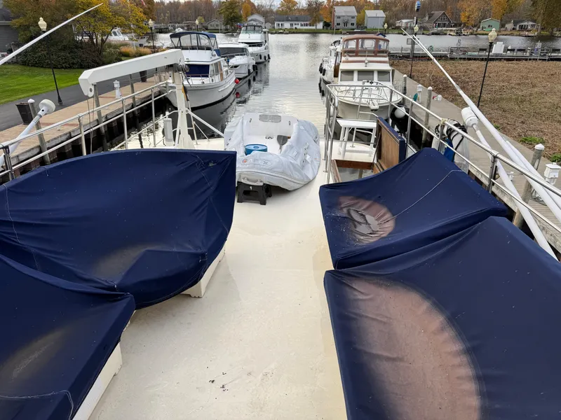 Slide: The Image of 1978 Hatteras 58 MY yacht deck with blue covers, docked in a marina. - 11