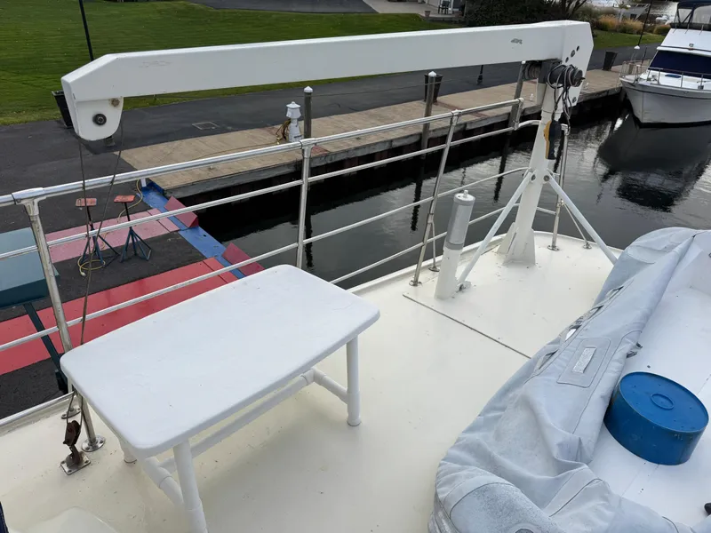 Slide: The Image of 1978 Hatteras 58 MY yacht deck with crane and table, docked at marina. - 13