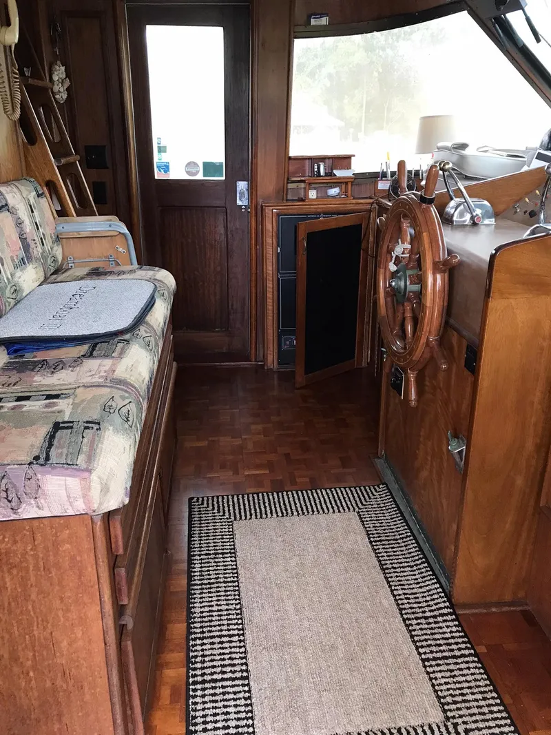 Slide: The Image of 1978 Hatteras 58 MY yacht interior with wooden helm and seating area. - 19
