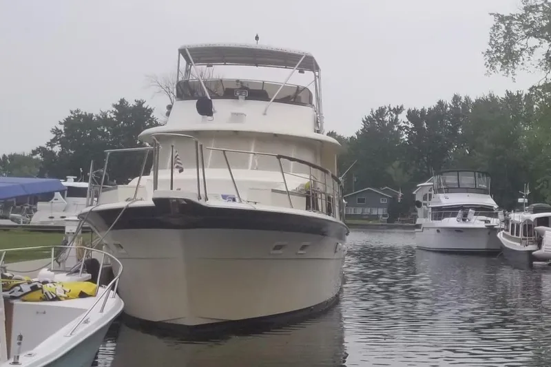 Slide: The Image of 1978 Hatteras 58 MY yacht docked in a serene marina setting. - 2