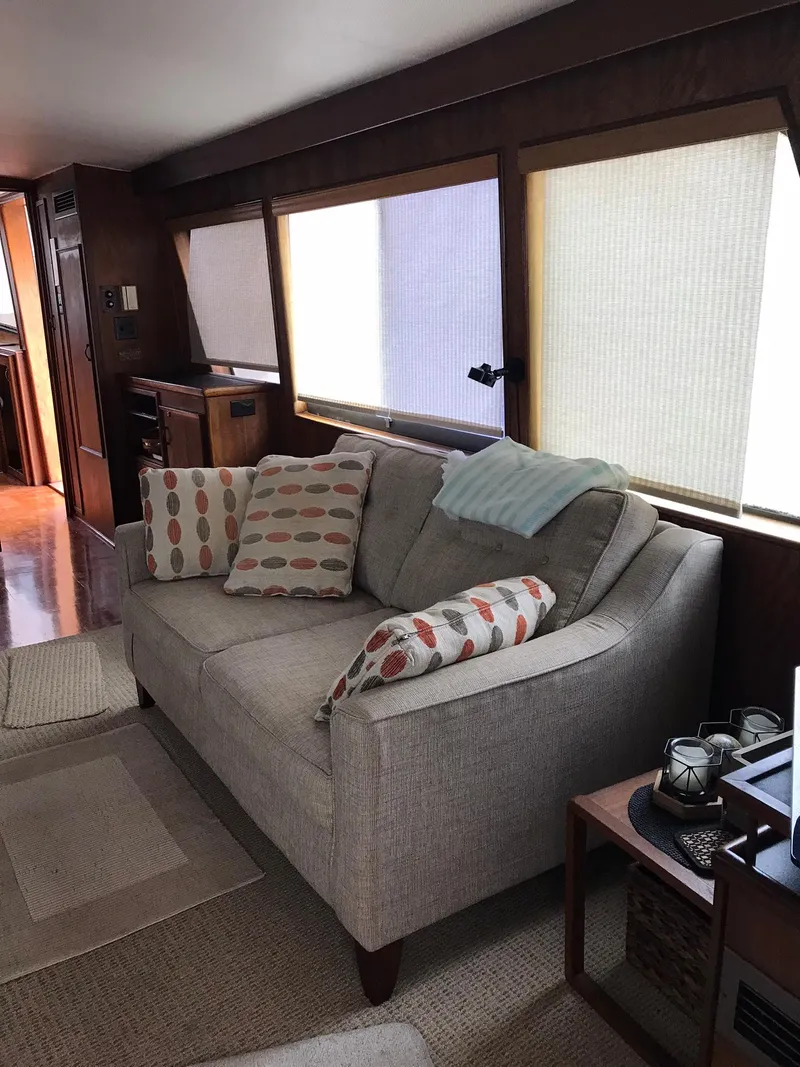Slide: The Image of Interior of a 1978 Hatteras 58 MY yacht with a cozy sofa and large windows. - 25