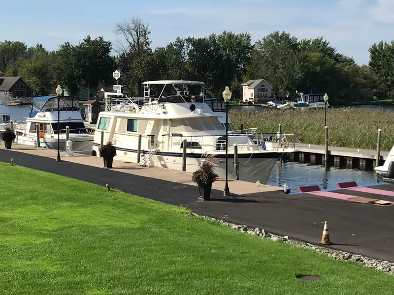 Slide: The Image of 1978 Hatteras 58 MY yacht docked at a marina with lush green surroundings. - 3