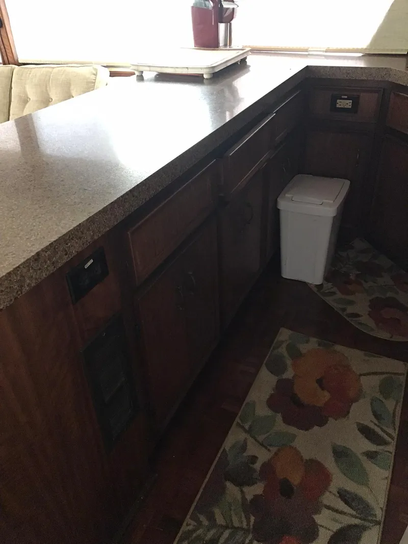 Slide: The Image of 1978 Hatteras 58 MY kitchen with wooden cabinets and floral rugs. - 37