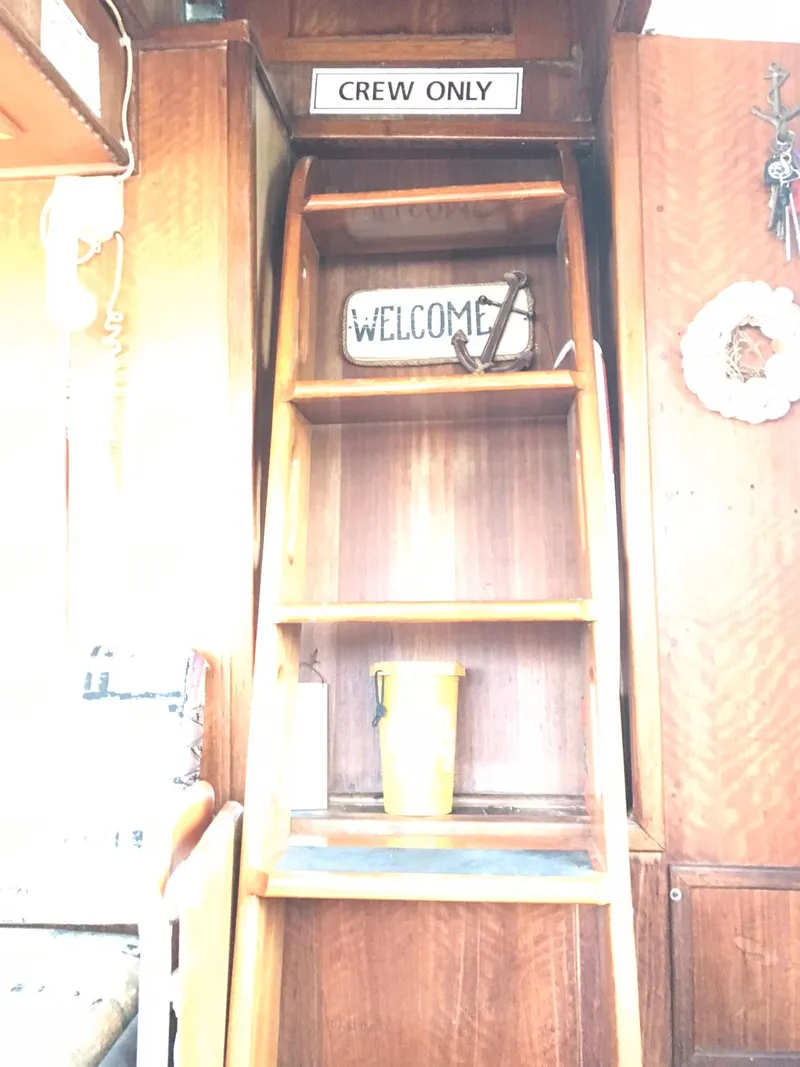 Slide: The Image of 1978 Hatteras 58 MY interior with 'Crew Only' and 'Welcome' signs on wooden shelves. - 45