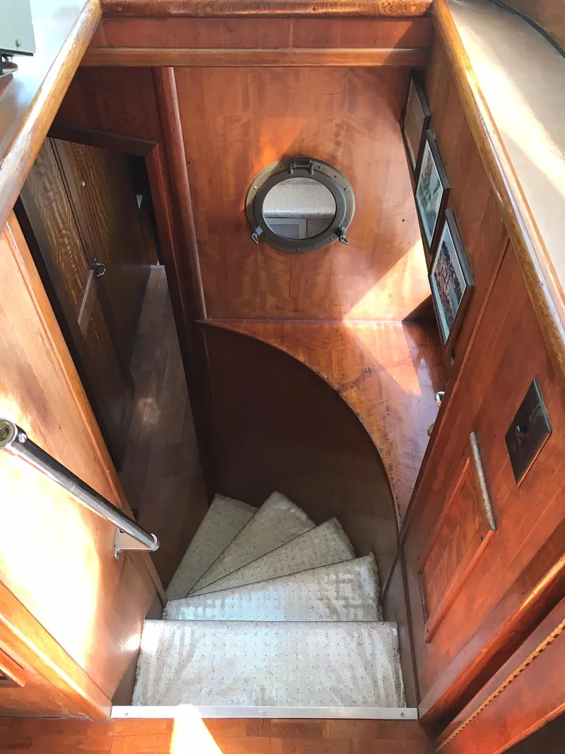 Slide: The Image of 1978 Hatteras 58 MY yacht interior staircase with wooden paneling and porthole. - 47