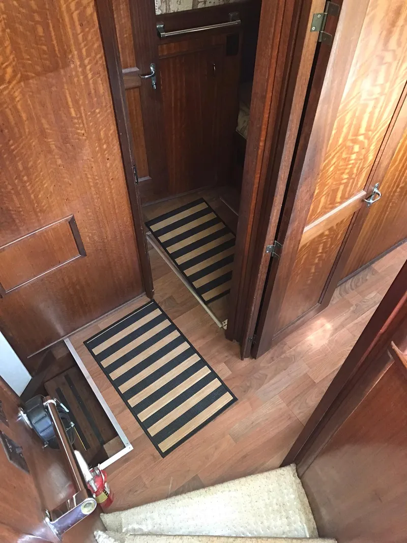 Slide: The Image of Interior hallway of a 1978 Hatteras 58 MY yacht with wooden paneling and striped rugs. - 49