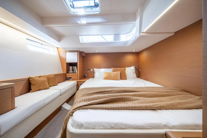 Slide: The Image of Luxurious cabin interior of 2023 Jeanneau 65 yacht with skylight and cozy bedding. - 15