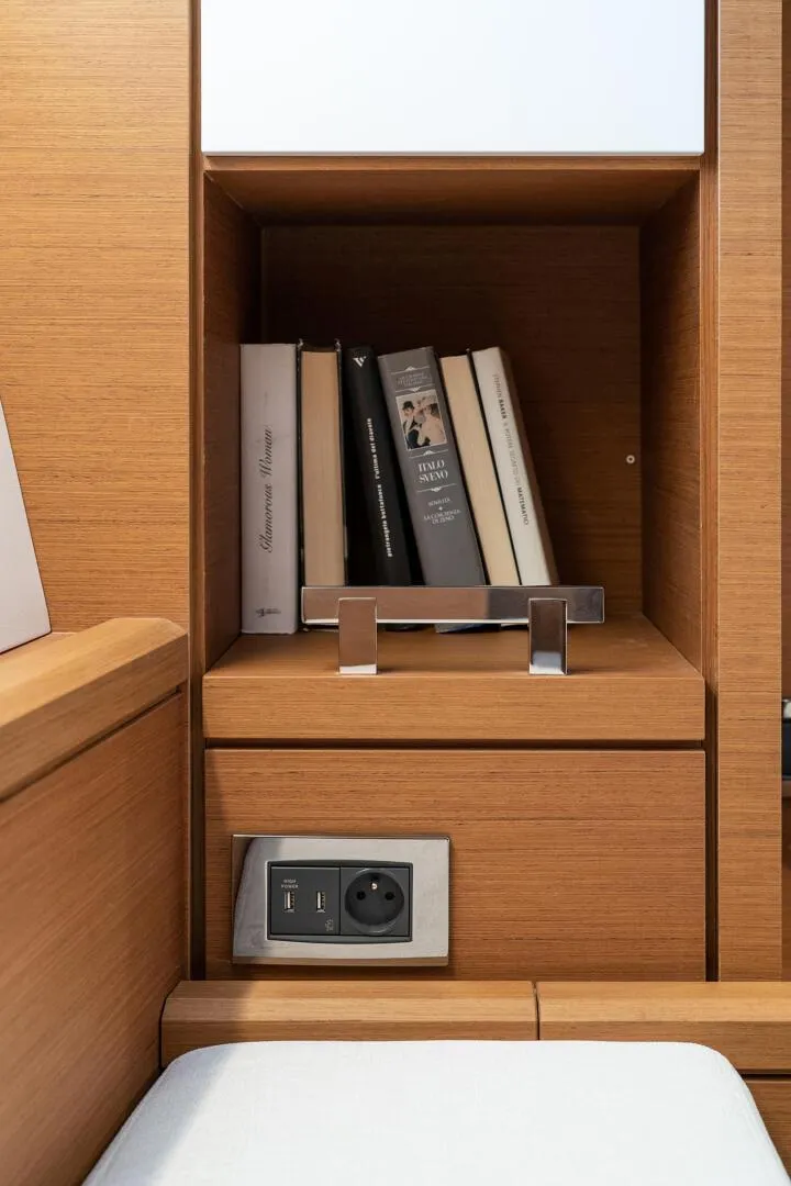 Slide: The Image of Bookshelf and power outlet in 2023 Jeanneau 65 yacht interior. - 18