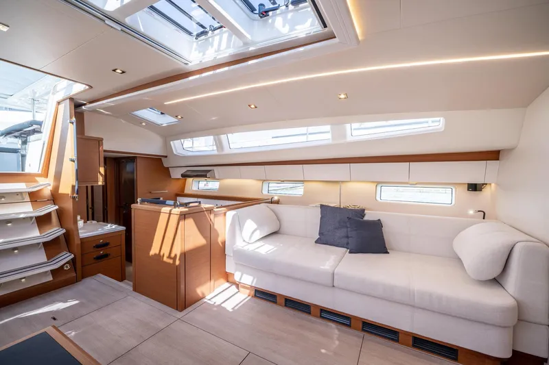 Slide: The Image of Modern interior of 2023 Jeanneau 65 yacht with white sofa and ample natural light. - 21