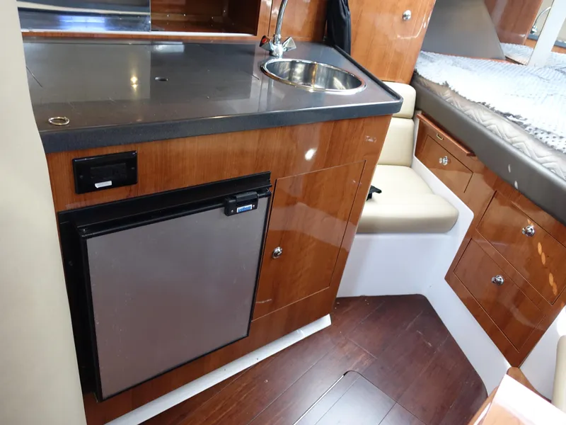 Slide: The Image of 2011 Regal 35 Express Cruiser interior with kitchenette and seating area. - 12