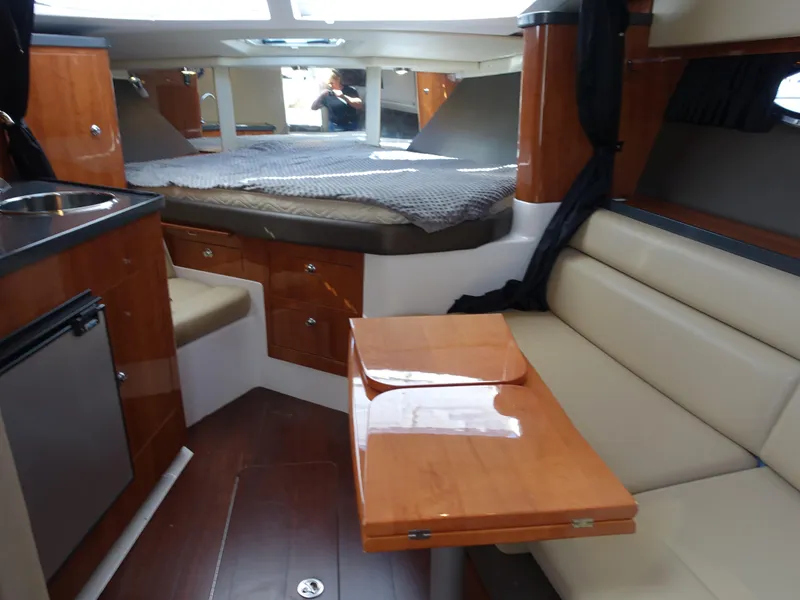 Slide: The Image of Interior of 2011 Regal 35 Express Cruiser with wood finishes and cozy seating area. - 14