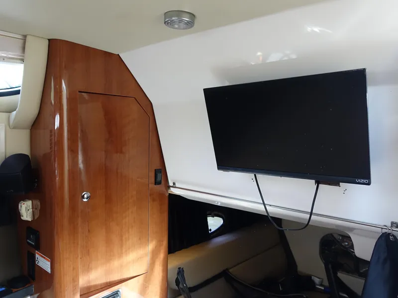 Slide: The Image of Interior of 2011 Regal 35 Express Cruiser with mounted TV and wooden cabinetry. - 15