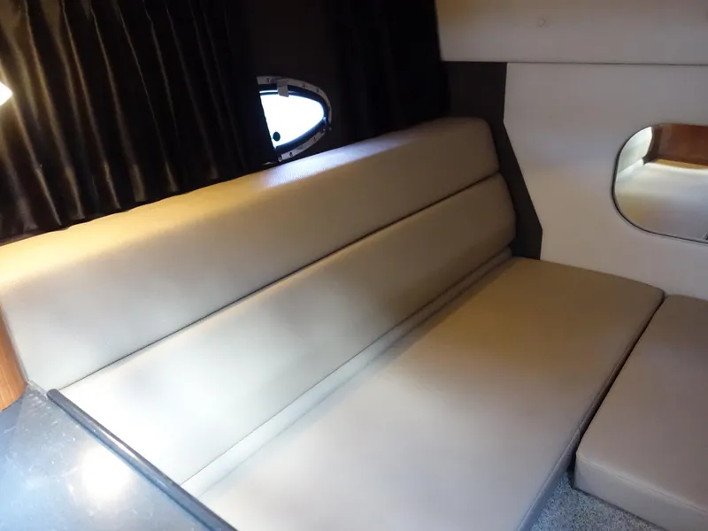 Slide: The Image of Interior seating of 2011 Regal 35 Express Cruiser with beige upholstery and window view. - 17