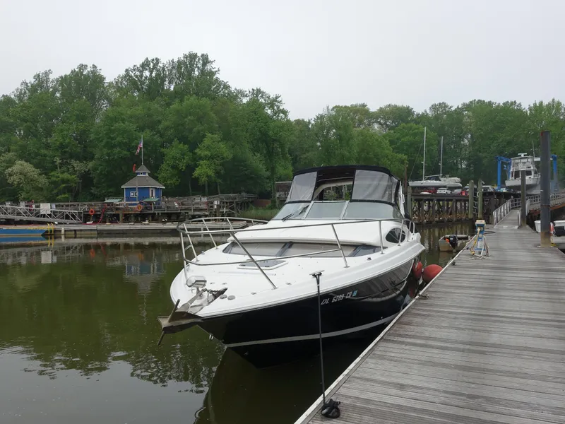 Slide: The Image of 2011 Regal 35 Express Cruiser docked by a serene, wooded marina. - 2