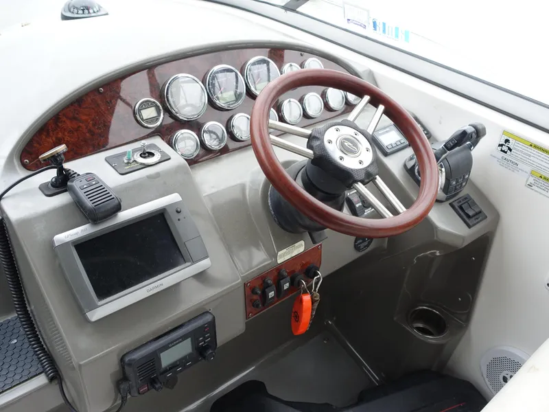 Slide: The Image of 2011 Regal 35 Express Cruiser helm with gauges, steering wheel, and navigation equipment. - 3