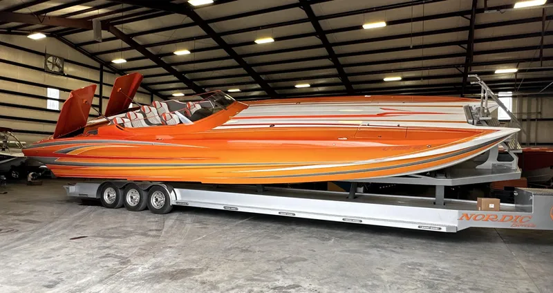 The Image of 2017 Nordic 43' Enforcer speedboat in vibrant orange, parked on a trailer in a warehouse. - 0