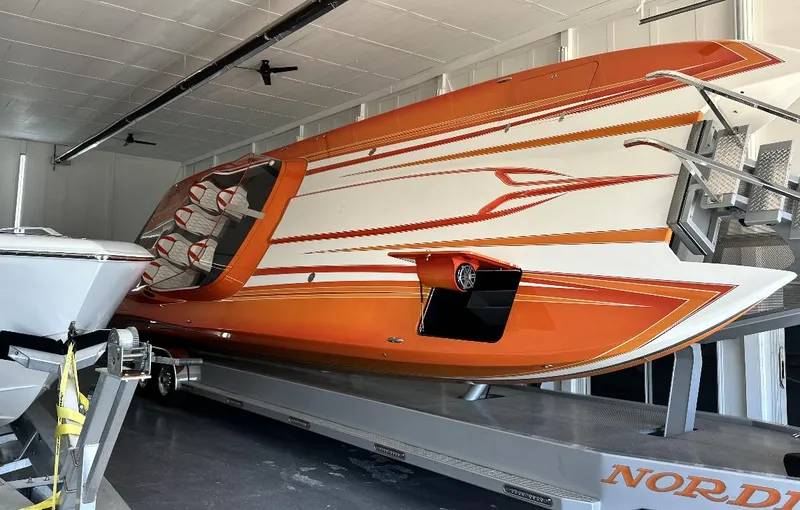 Slide: The Image of 2017 Nordic 43' Enforcer speedboat with orange and white design in storage. - 18