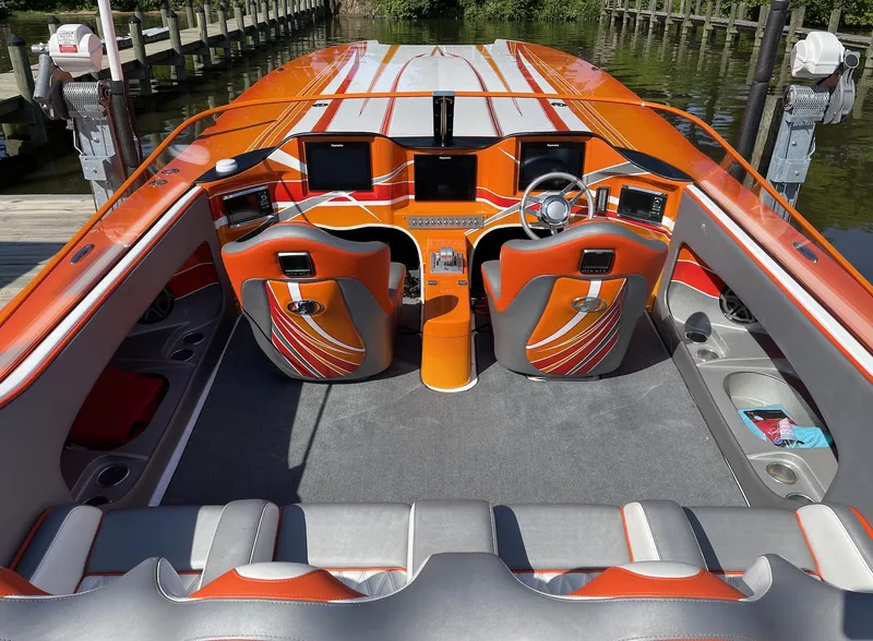 Slide: The Image of 2017 Nordic 43' Enforcer boat interior with orange and gray seating, dashboard, and controls. - 20