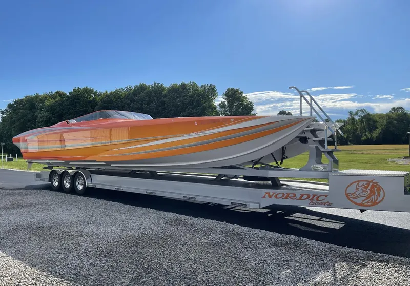 Slide: The Image of 2017 Nordic 43' Enforcer speedboat on a trailer, orange and white design. - 21