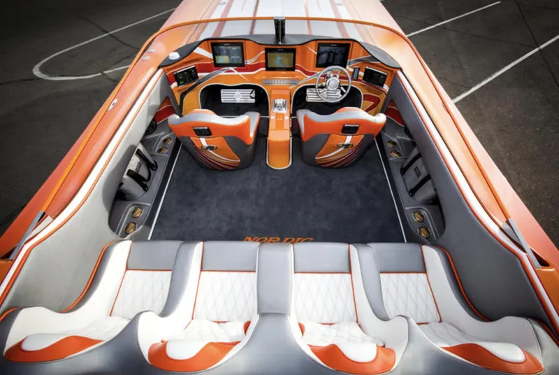 Slide: The Image of Interior of a 2017 Nordic 43' Enforcer speedboat with orange and white seating. - 28