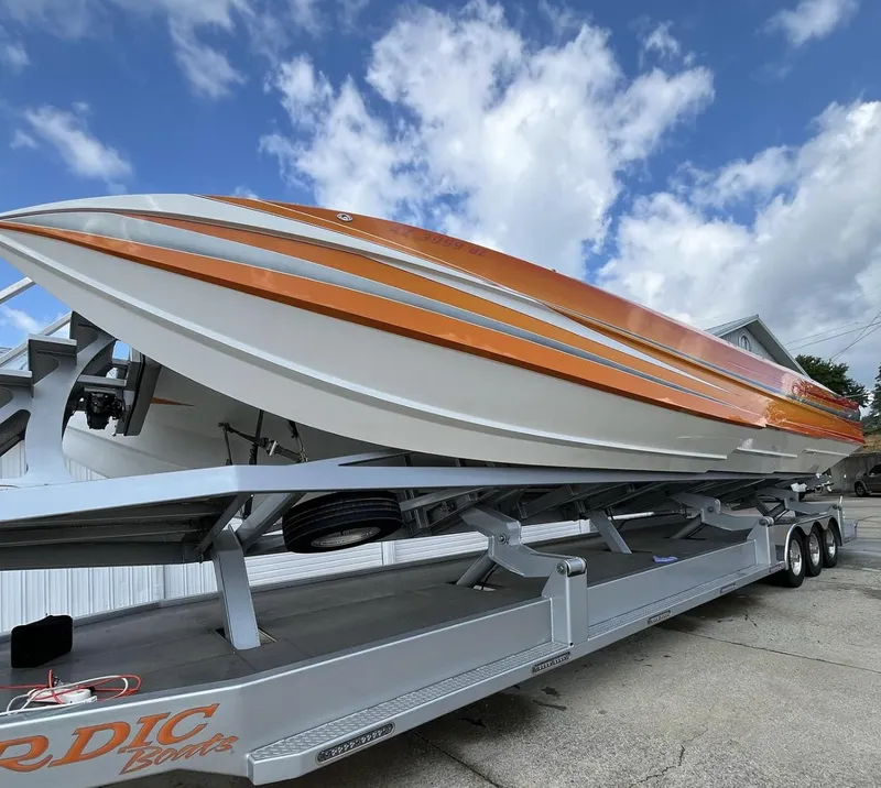 Slide: The Image of 2017 Nordic 43' Enforcer boat on trailer, orange and white design, under blue sky. - 3