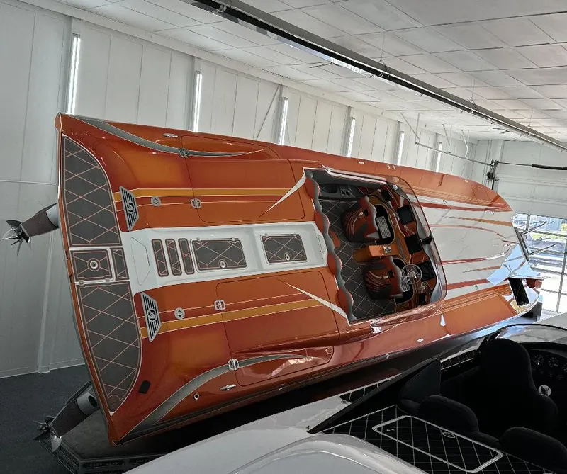 Slide: The Image of 2017 Nordic 43' Enforcer boat with sleek orange and white design in showroom. - 4