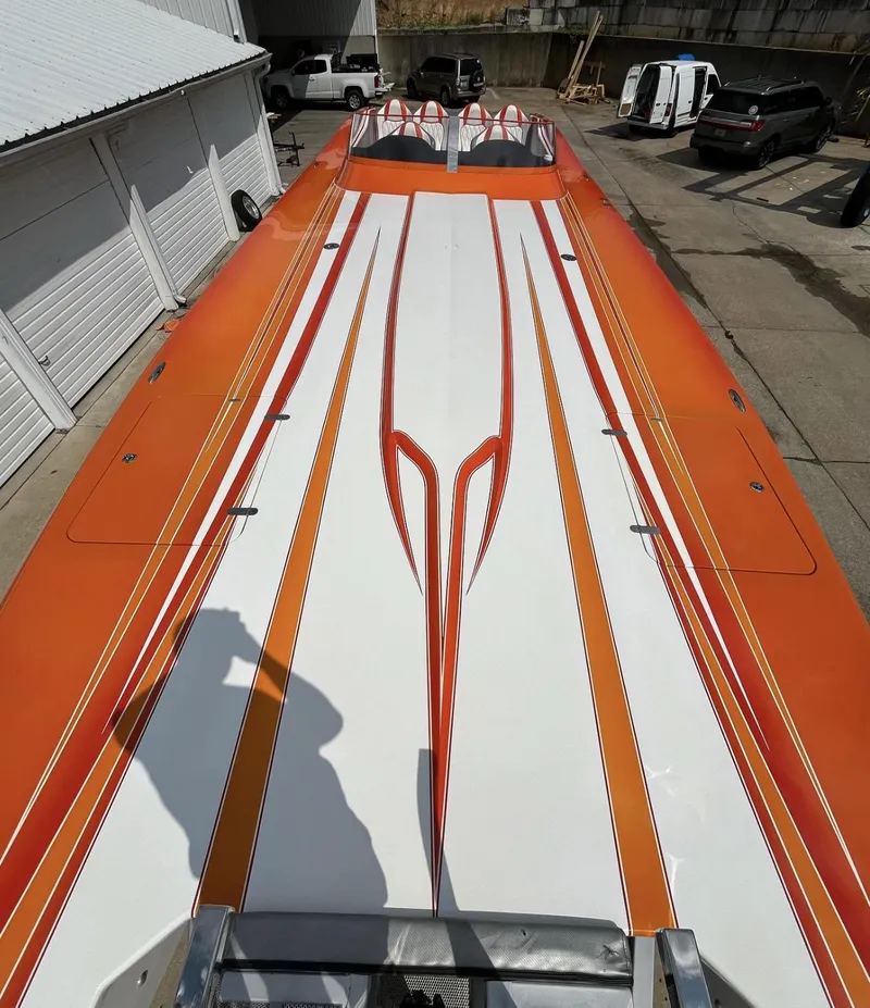 Slide: The Image of 2017 Nordic 43' Enforcer boat with orange and white design, parked outdoors. - 5