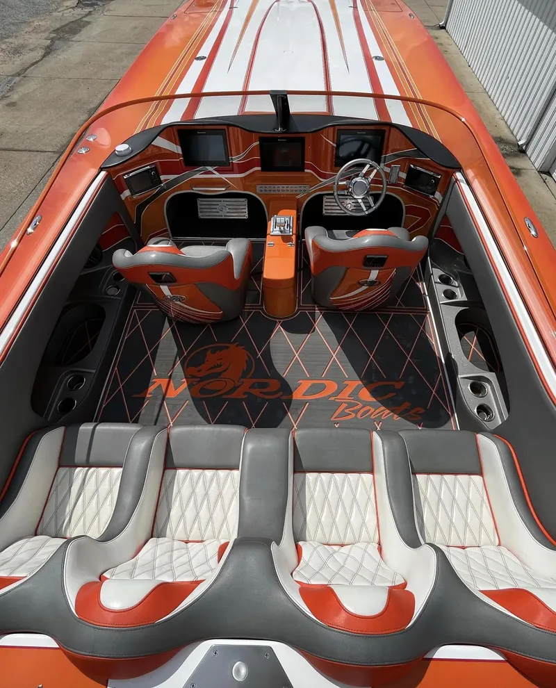 Slide: The Image of 2017 Nordic 43' Enforcer boat interior with orange and white seating and dashboard. - 6