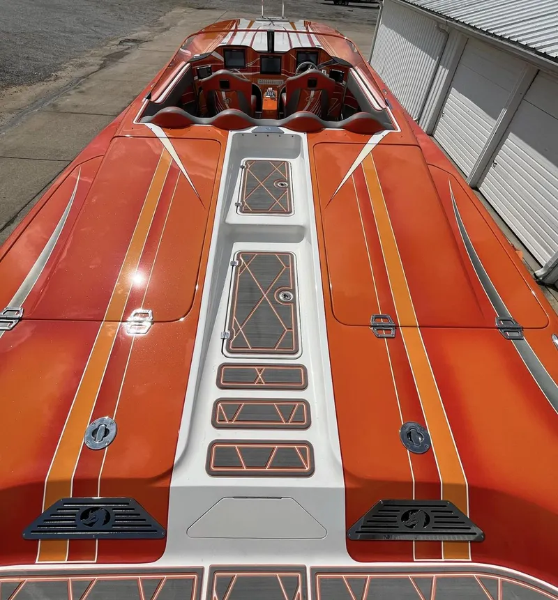 Slide: The Image of 2017 Nordic 43' Enforcer boat with vibrant orange and white design, docked near a building. - 8
