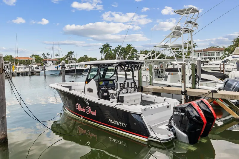 The Image of 2022 Blackfin 272 CC boat docked at a marina with twin Mercury engines. - 0