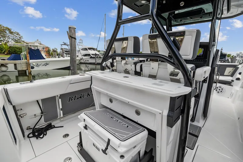 Slide: The Image of 2022 Blackfin 272 CC boat interior with seating and storage at a marina. - 12