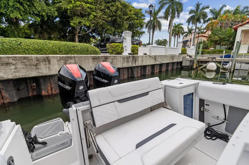 Slide: The Image of 2022 Blackfin 272 CC boat with dual Mercury engines docked by a canal. - 13