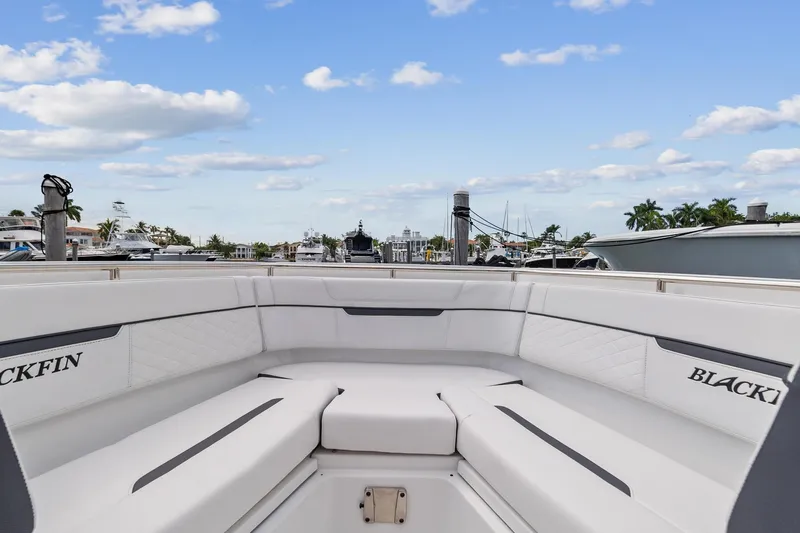Slide: The Image of 2022 Blackfin 272 CC boat interior with white seating, docked at marina. - 8
