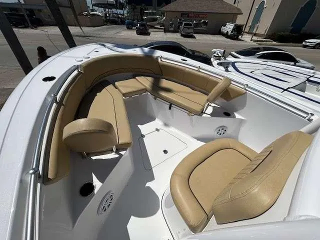 Slide: The Image of 2023 Sportsman 232 Open boat with beige seating in a marina setting. - 11
