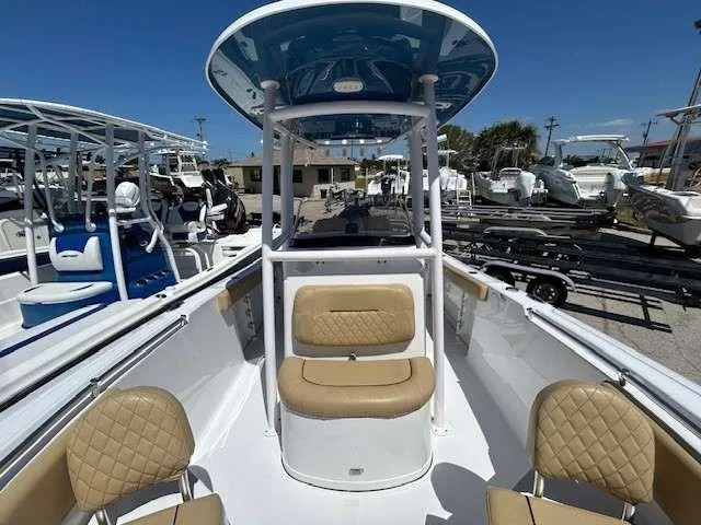 Slide: The Image of 2023 Sportsman 232 Open boat with tan seating and blue T-top in a marina. - 7