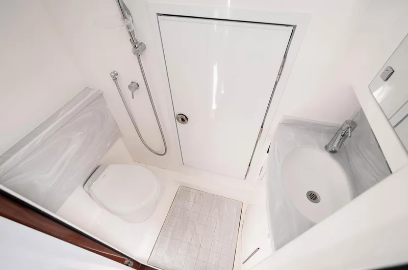 Slide: The Image of 2022 Valhalla Boatworks V46 Center Console bathroom with shower, toilet, and sink. - 11