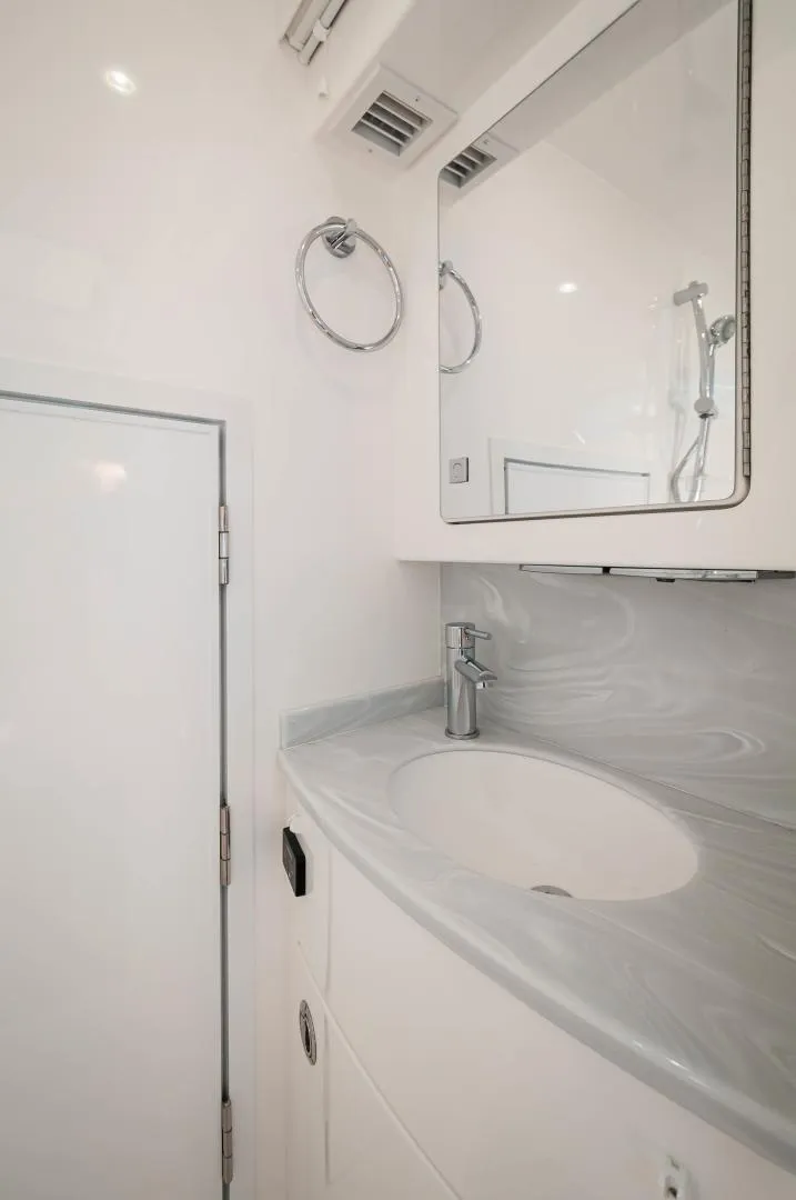 Slide: The Image of 2022 Valhalla Boatworks V46 Center Console bathroom with modern sink and mirror. - 12