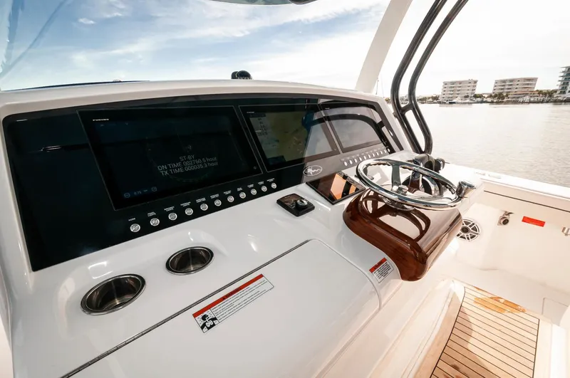 Slide: The Image of 2022 Valhalla Boatworks V46 Center Console helm with advanced navigation displays and wooden steering wheel. - 16