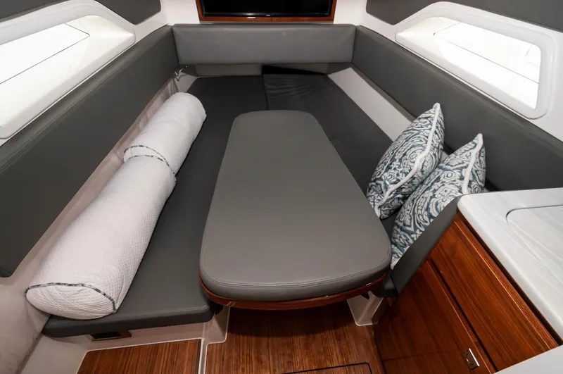 Slide: The Image of 2022 Valhalla Boatworks V46 Center Console cabin with grey seating and decorative pillows. - 7