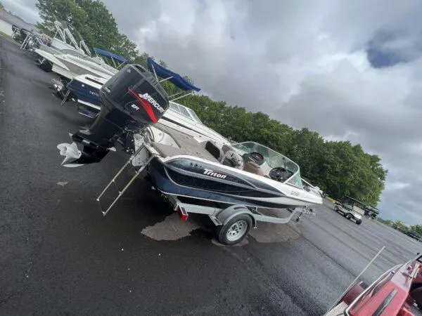 Slide: The Image of 2005 Triton 190 FS boat with Mercury outboard motor in a parking lot. - 4