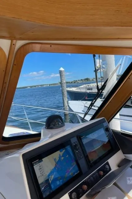 Slide: The Image of 2006 Sabre 38 Hard Top Express helm with navigation screens, docked by the water. - 12